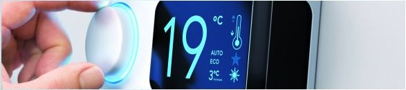 Hand bedient das Display eines wandmontierten Klimagerätes bei 19 Grad
